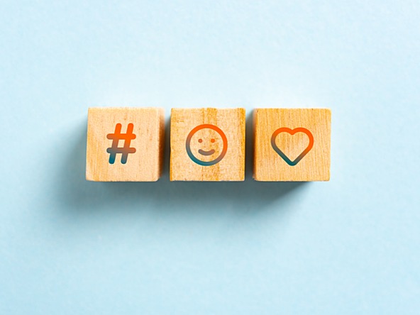 three wooden blocks showing hashtag, smiling face and loveheart